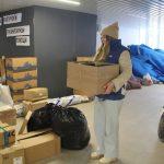 На фото девушка волонтёр из народного фронты разбирает гуманитарную помощь по коробкам.