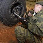 На фото военные российские солдаты воюющие на Украине меняют колёса шин на боевой транспортной машине.