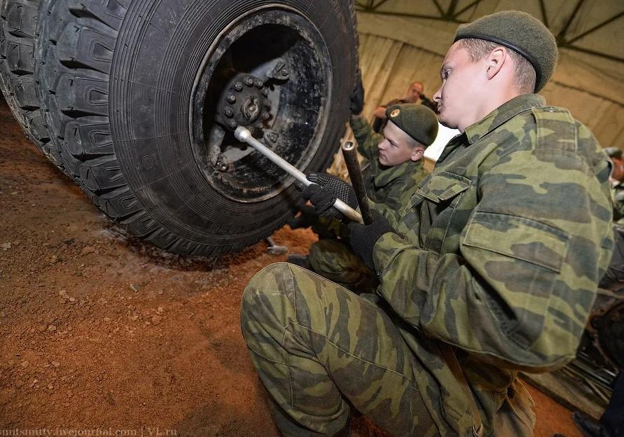 На фото военные российские солдаты воюющие на Украине меняют колёса шин на боевой транспортной машине.