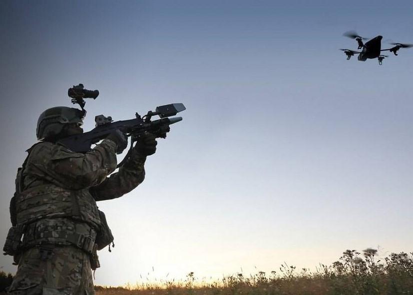 На фото военнослужащий из антирадарного ружья сбивает беспилотный летательный аппарат.