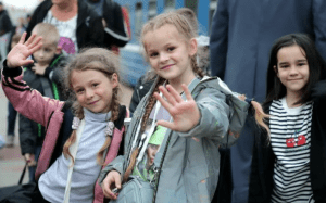 На фото маленькие дети из городов Донбасса прибыв с родителями беженцами благодарят всю Россию за тёплый приём и обеспечение все необходимым для временного проживания в пунктах для вынужденных переселенцев. Им понадобятся пожертвованные средства, что бы жить.