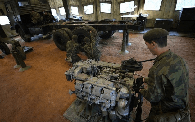 На фото солдаты ремонтируют военные машины прямо на передовой линии фронта.