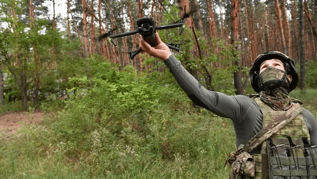 На фото боец запускает БПЛА для проведения воздушной разведки за линией фронта на специальной военной операции, такие квадрокоптеры и дроны нужны солдатам на Донбассе.