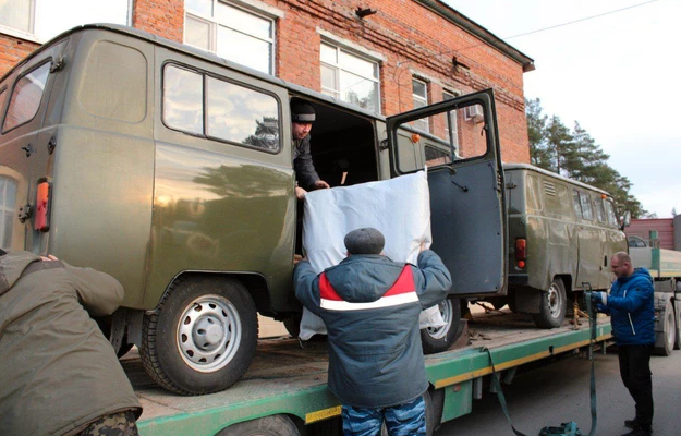 На фото волонтёры грузят автомобили УАЗ типа Буханка на ж/д платформу для отправки машин в зону специальной военной операции.