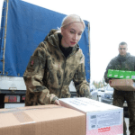 На фото супруга военного солдата помогает грузить гумпомощь на Донбасс для бойцов-фронтовиков.