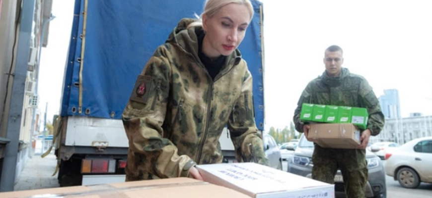 На фото супруга военного солдата помогает грузить гумпомощь на Донбасс для бойцов-фронтовиков.