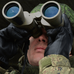 На фото военный солдат смотрит в оптику для наблюдения за врагом на большом удалении.